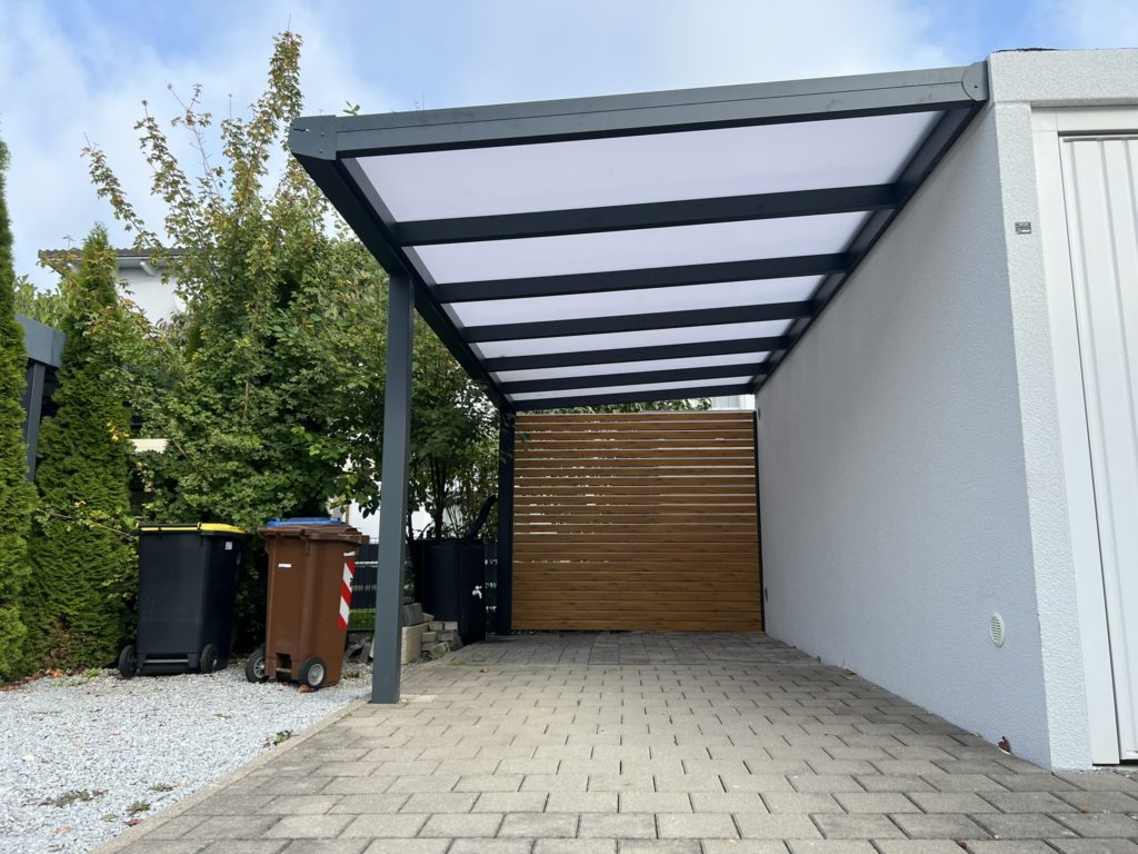 Carport mit Wandanschluss aus Aluminium in Gersthofen mit Polycarbonat-Dach und Seitenwand in Holzoptik