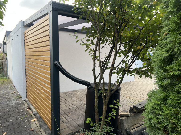 Carport mit Wandanschluss aus Aluminium in Gersthofen mit Polycarbonat-Dach und Seitenwand in Holzoptik